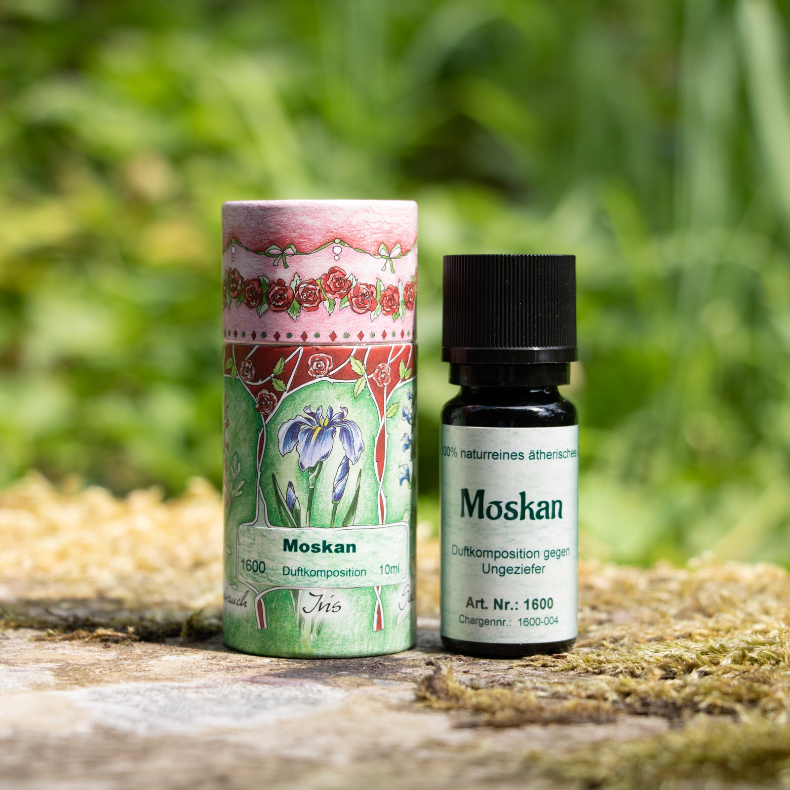 Moskan Flasche, daneben steht eine Rosa-grüne Papier Schmuckdose.